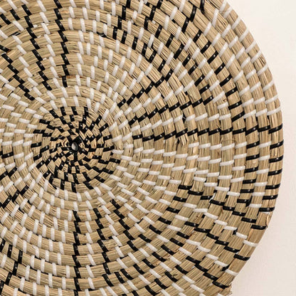 Detailed closeup of handcrafted black natural seagrass wall basket with geometric stepped zigzag pattern for boho decor.