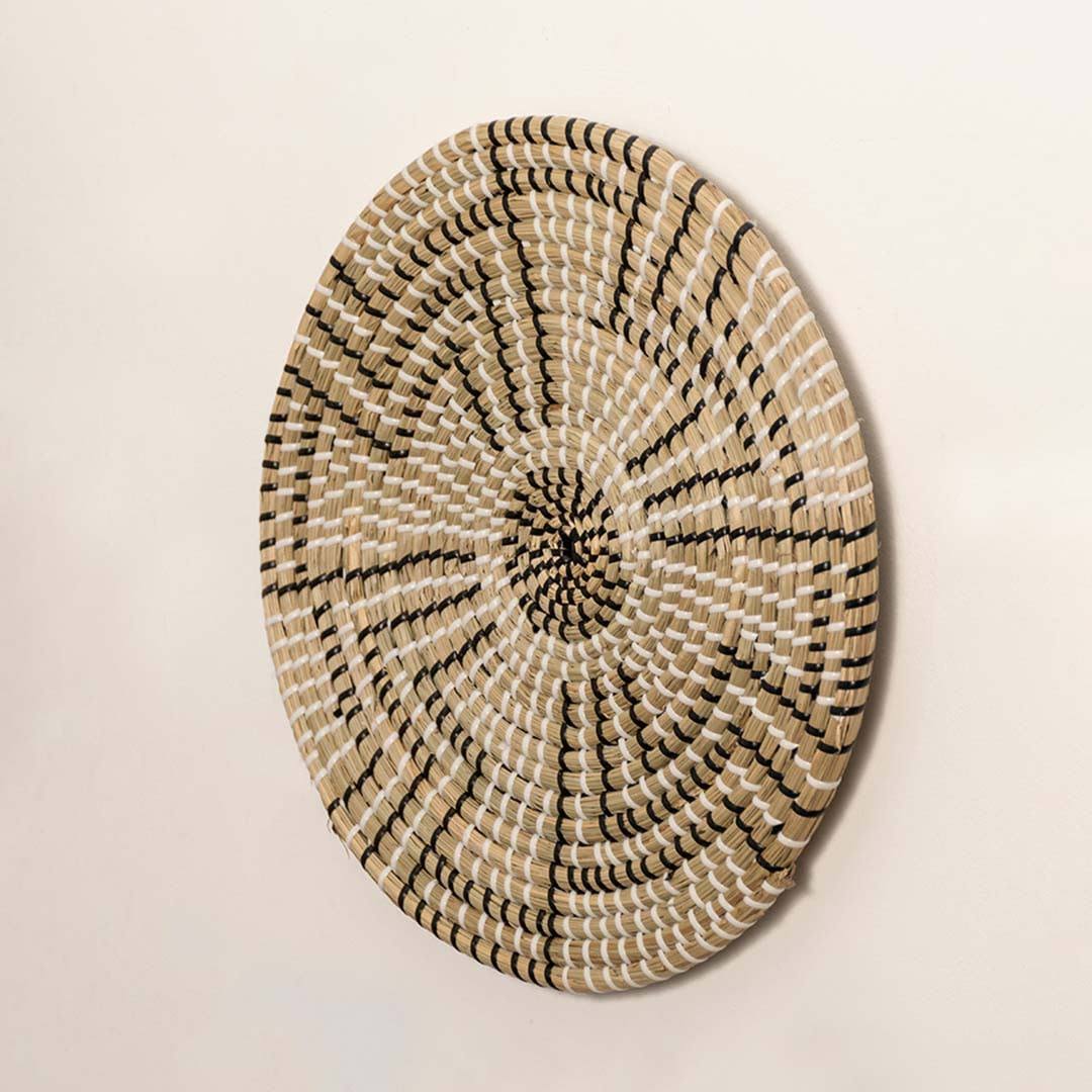 Side view of handcrafted black and natural seagrass wall basket with geometric stepped maze pattern for boho home wall decor.