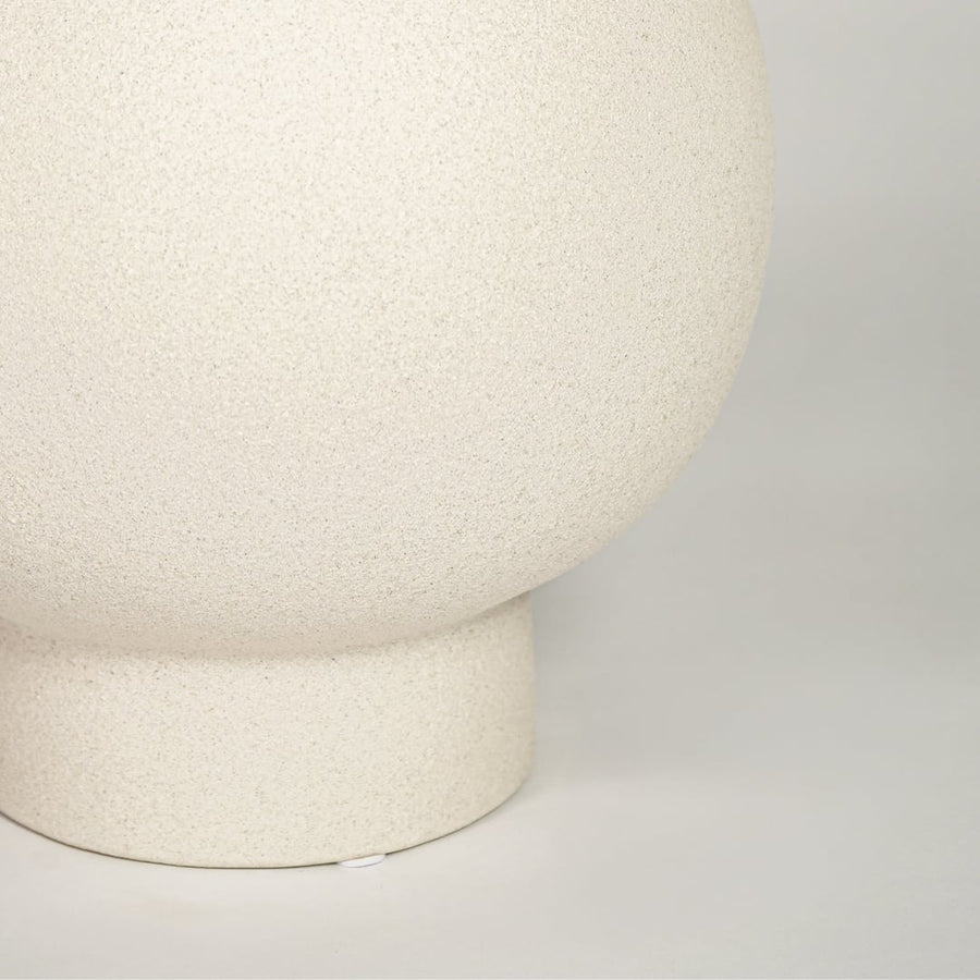 Closeup of matte white ceramic round vase with minimalist design ideal for elegant home decor shelf or side table styling.