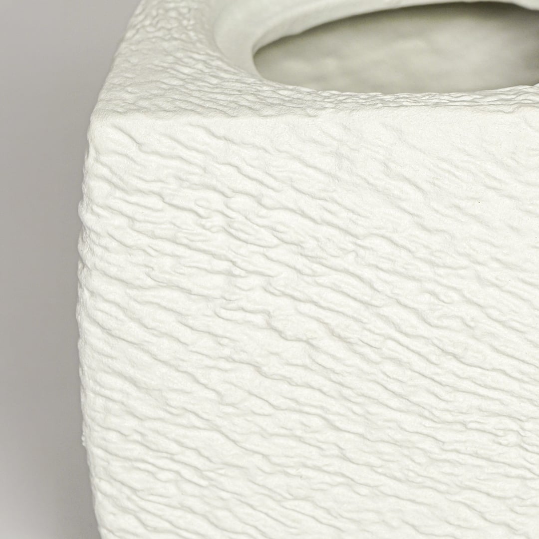 Close up view white textured ceramic planter showing rough sculpted surface matte finish decorative ceramic accent.
