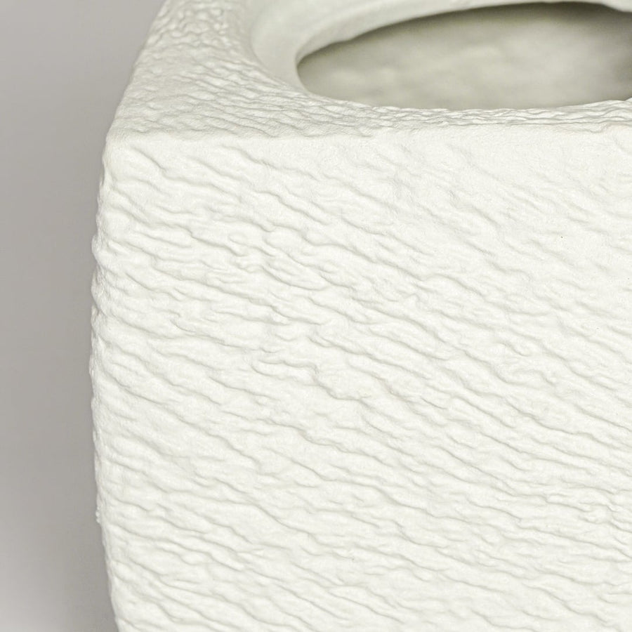 Close up view white textured ceramic planter showing rough sculpted surface matte finish decorative ceramic accent.