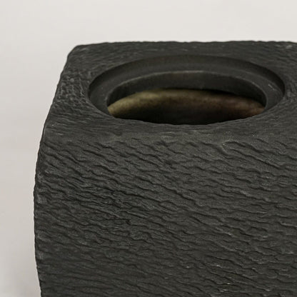 Closeup of black ceramic planter with textured matte finish for elegant tabletop and shelf decor styling ideas.