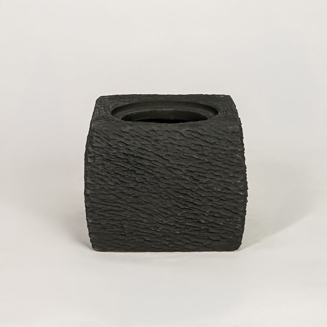 Black ceramic planter with textured matte finish for modern tabletop shelf and console decor placement.
