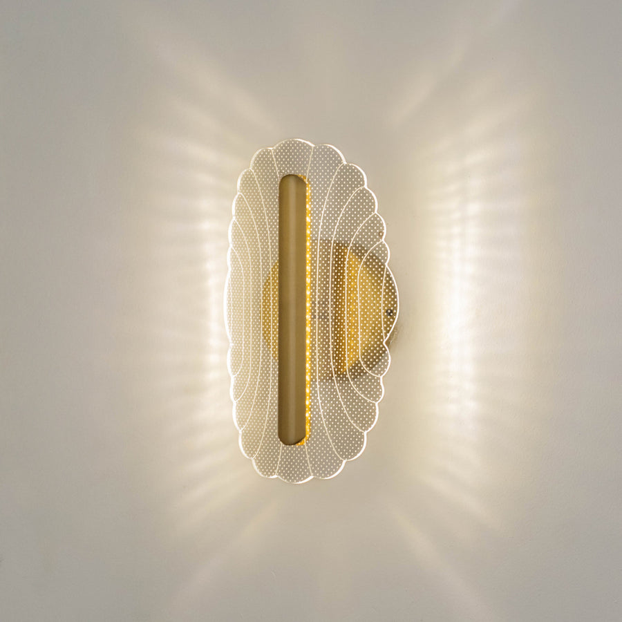 Decorative wall light in gold metal finish with textured glass diffuser for bedroom or living decor lighting placement white background.