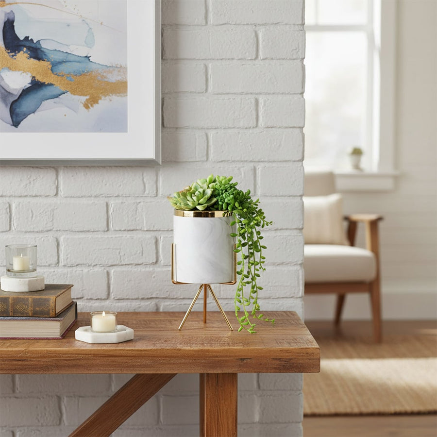 A modern white marble finish planter with gold metal stand styled on a clean surface creating a soft lifestyle look for elegant decor.