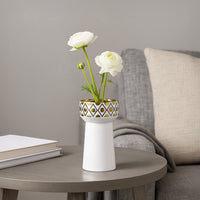 A modern white decorative vase with gold detailing styled on a clean surface creating an elegant lifestyle look for contemporary home decor.
