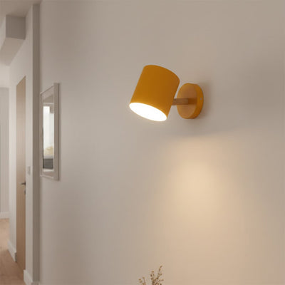 Modern white and brass spotlight wall light creating cozy hallway ambiance with warm interior lighting.