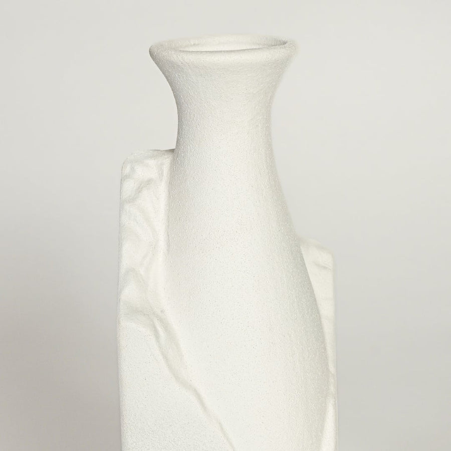 Close up view of white ceramic vase highlighting sculpted crack detail matte texture and minimalist geometric shape.