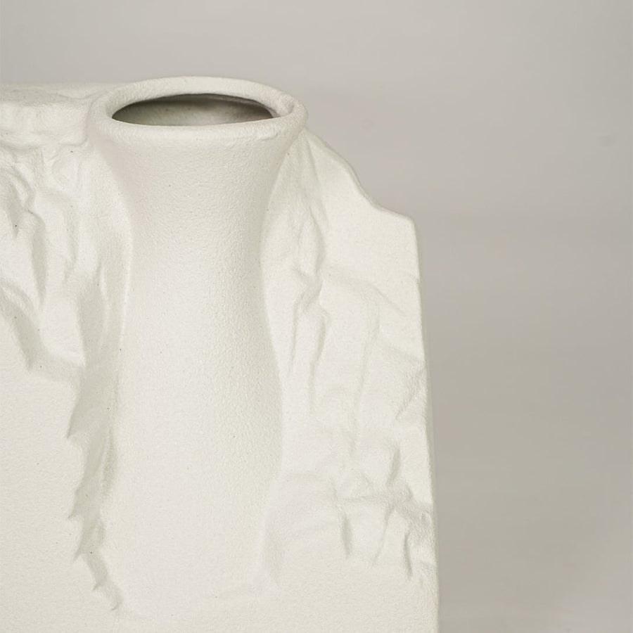 Closeup of white ceramic vase with sculpted textured finish for elegant tabletop and shelf decor styling.