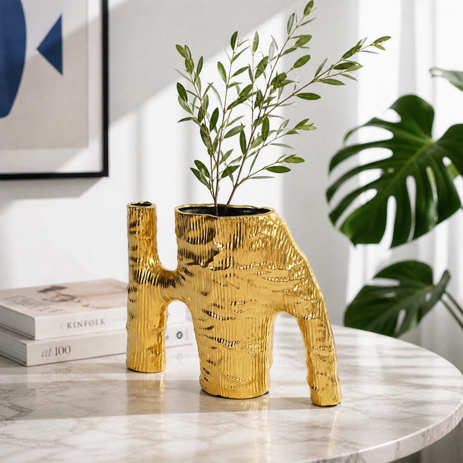 Gold textured metal elephant planter with green plant placed on marble table for modern home decor styling.