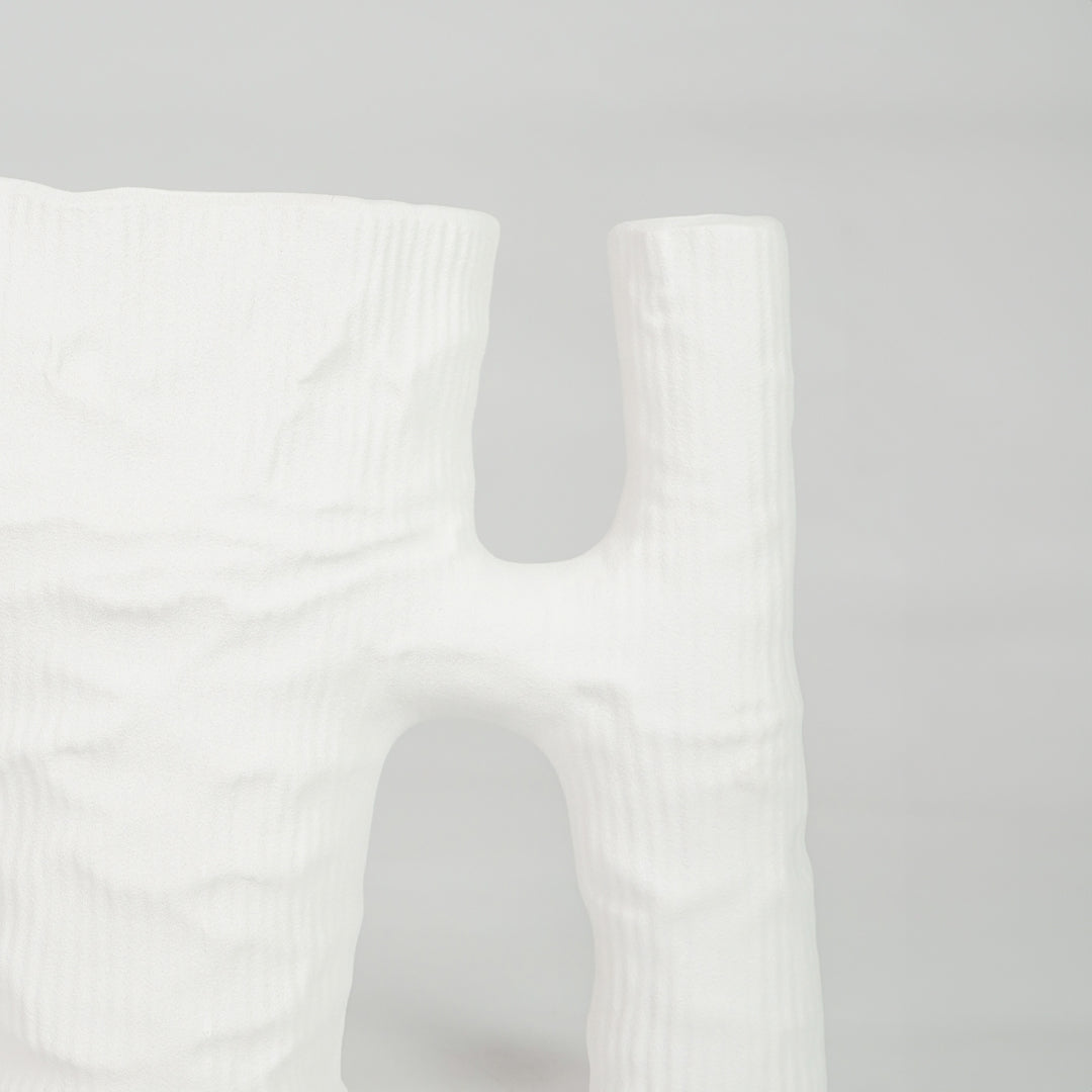 Closeup image of white ceramic artistic vase for modern tabletop placement with minimal matte texture decor styling.
