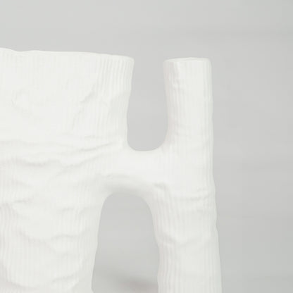Closeup image of white ceramic artistic vase for modern tabletop placement with minimal matte texture decor styling.