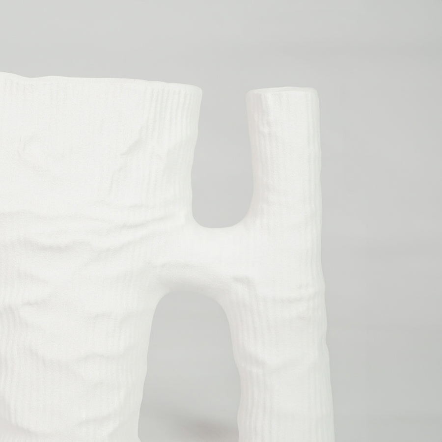 Closeup image of white ceramic artistic vase for modern tabletop placement with minimal matte texture decor styling.