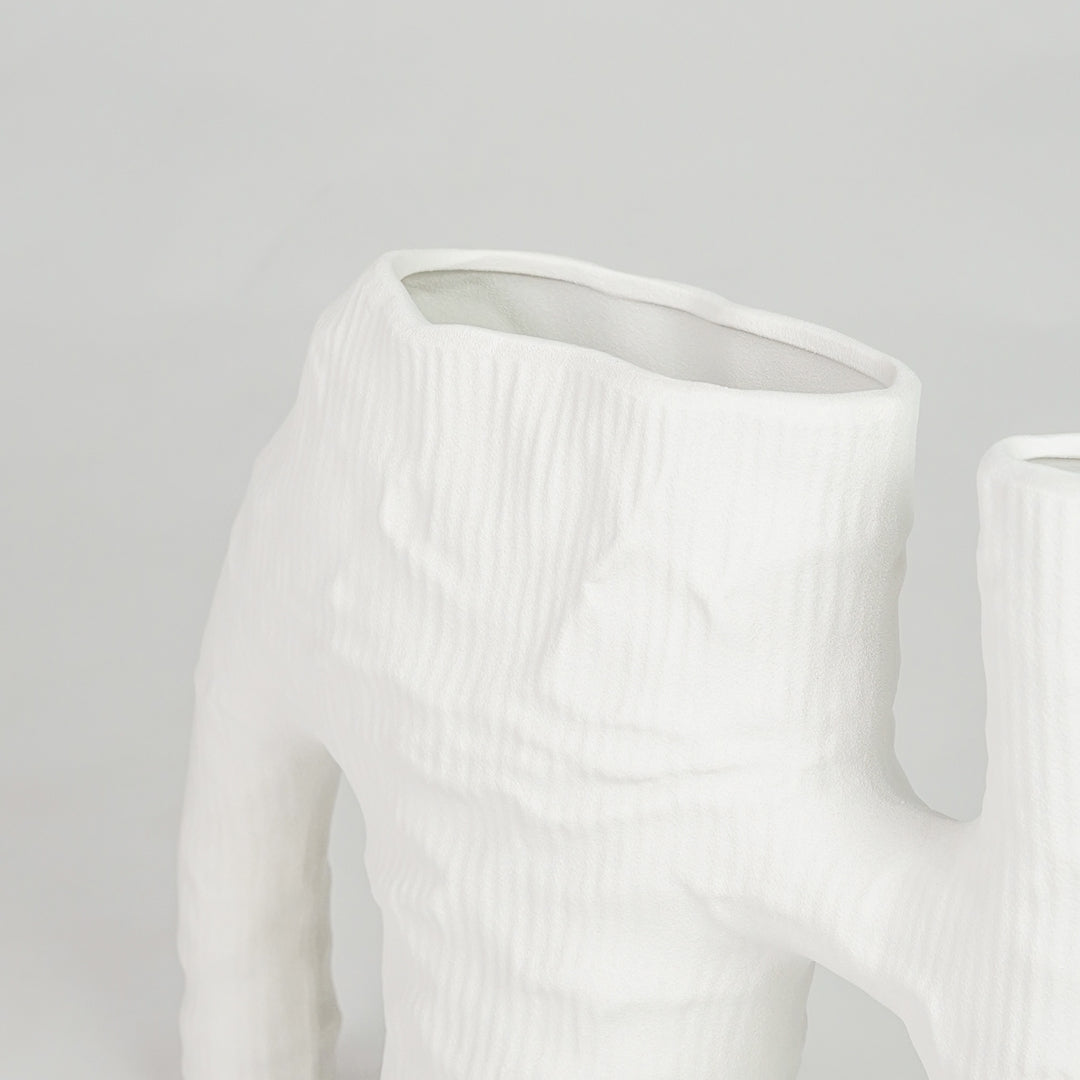 Closeup image of white ceramic abstract vase for modern tabletop decor styling with artistic matte textured finish.
