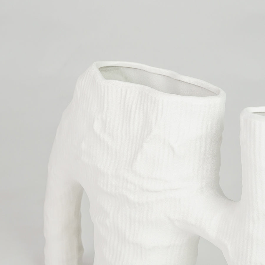 Closeup image of white ceramic abstract vase for modern tabletop decor styling with artistic matte textured finish.