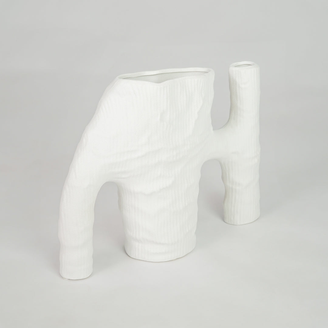 White sculptural ceramic vase for contemporary shelf placement and elegant indoor living room decor styling accent piece.