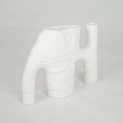 White sculptural ceramic vase for contemporary shelf placement and elegant indoor living room decor styling accent piece.