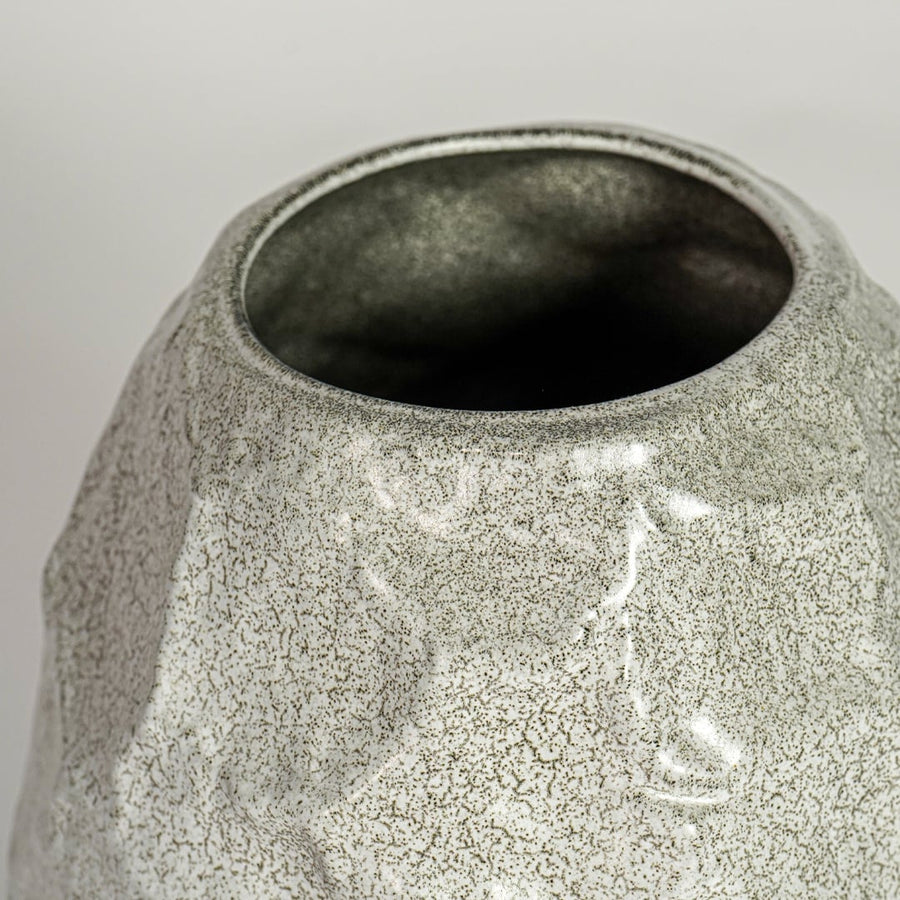 Close up view white textured ceramic vase showing organic sculpted surface glossy finish decorative ceramic accent for home styling.