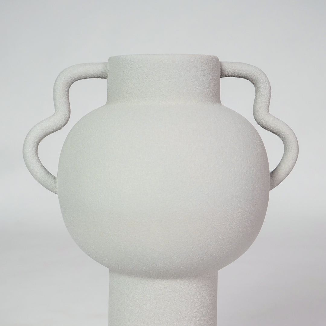 Closeup image of white ceramic handle vase for modern living room tabletop decor with smooth matte finish styling.