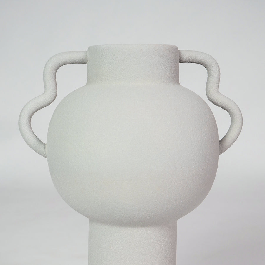 Closeup image of white ceramic handle vase for modern living room tabletop decor with smooth matte finish styling.