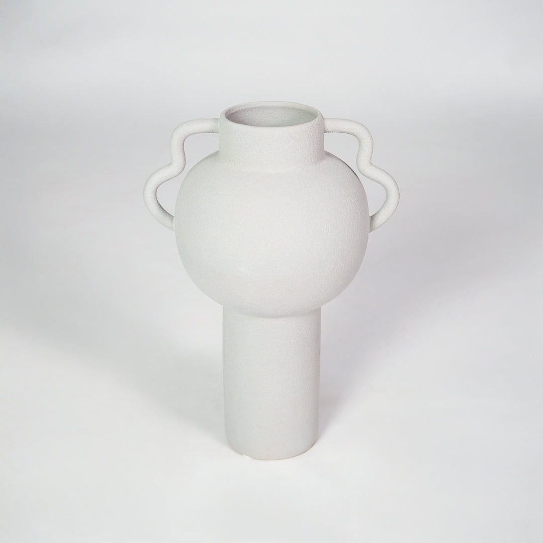 White ceramic vase with side handles for modern shelf placement and elegant indoor home decor styling accent.