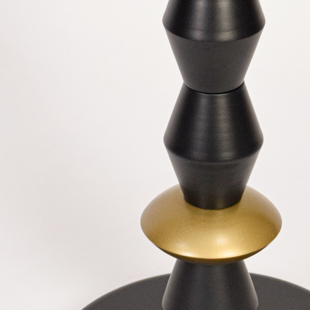 Floor lamp closeup highlighting stacked black metal forms with gold accents and fabric shade showcasing premium craftsmanship and vertical design.