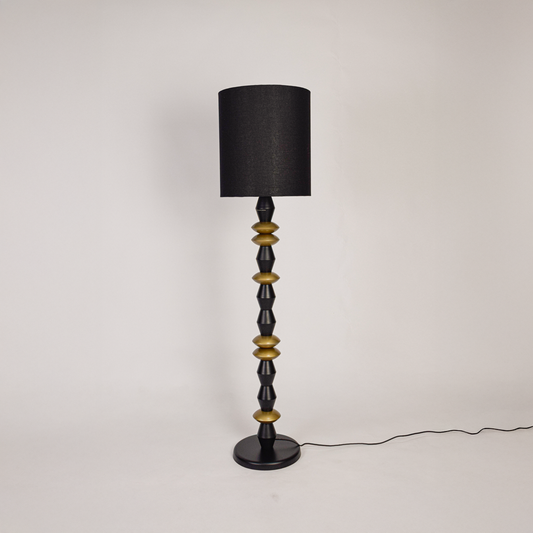 Floor lamp floor light off on white background featuring black fabric shade with geometric black and gold metal base for minimalist product display.