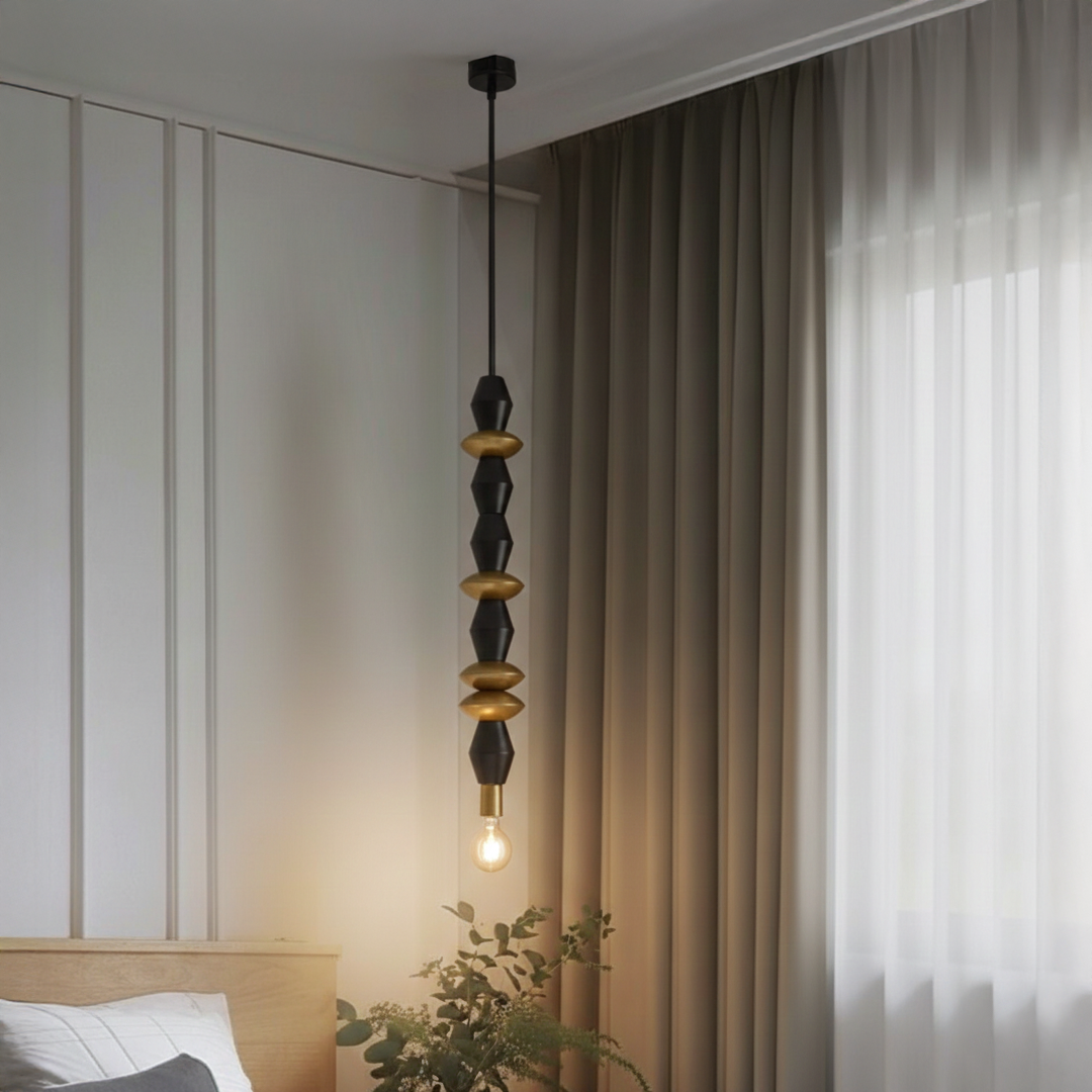 Black and gold metal pendant light with decorative beads adding warmth to modern bedroom interiors.