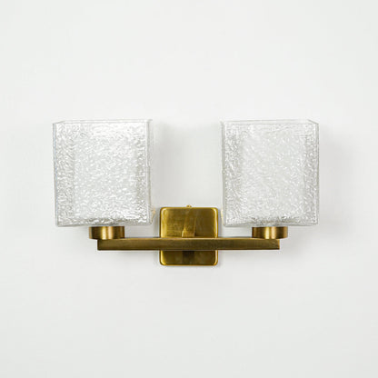 Contemporary gold wall light with ribbed glass shades mounted on clean white wall background ideal for modern interior lighting setup.

