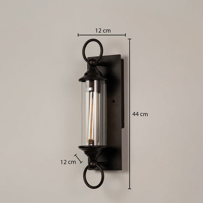 Black metal wall sconce with clear glass tube shown with dimensions 44 cm height 12 cm width and 12 cm depth for easy fitting.