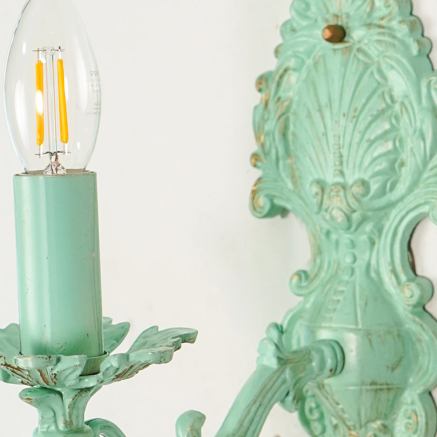 Closeup image of aluminium era small light wall sconce with floral white shade for elegant living room interior styling.