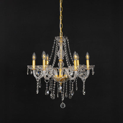 Gold chandelier with lights off highlighting crystal drops and glass body photographed on black background.
