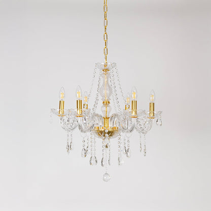 Gold chandelier with lights off featuring crystal accents and glass frame on plain white background.