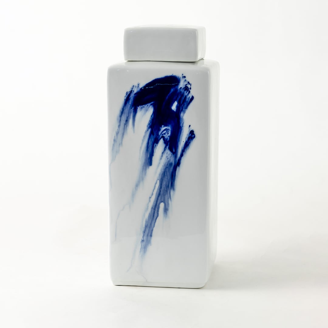 Tall white ceramic jar with blue brushstroke design displayed on plain background for modern artistic décor.