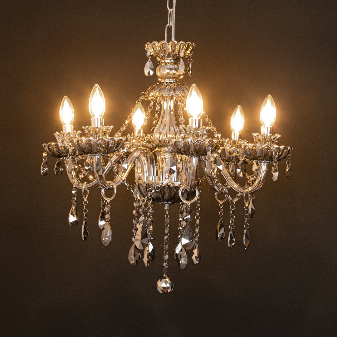 Black crystal chandelier glowing softly on black background creating a dramatic luxury feature for home ceilings.