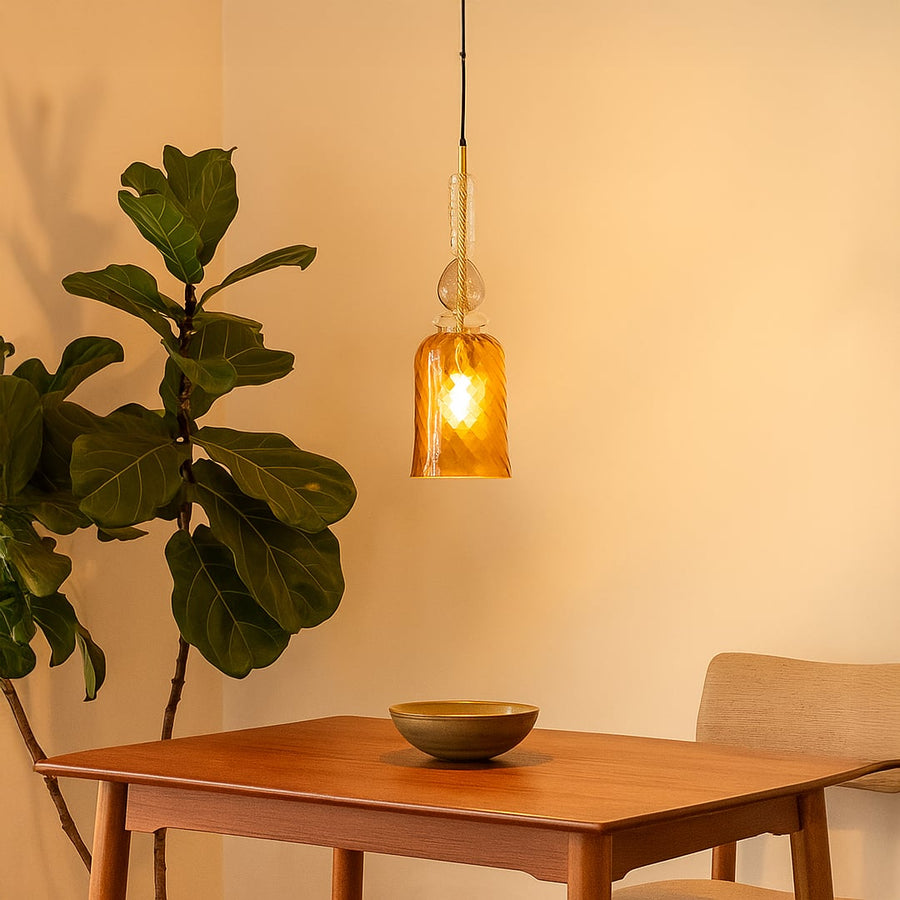 A modern gold glass pendant light featuring an artistic textured finish that adds luxury and elegance to contemporary dining spaces.
