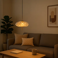 Amber glass pendant light above sofa creating cozy ambiance with refined contemporary elegance.