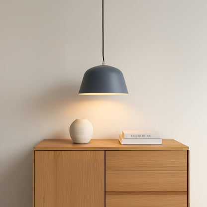 Matte blue dome pendant light illuminating a modern wooden sideboard creating a calm and sophisticated interior setting.