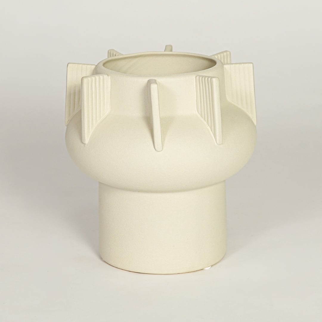 Modern beige ceramic statement vase with rounded form and vertical sculptural accents for coffee table console or shelf styling.