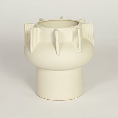Modern beige ceramic statement vase with rounded form and vertical sculptural accents for coffee table console or shelf styling.