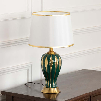 Table lamp with green and gold ceramic base and white shade displayed on a clean white background for clear product view.