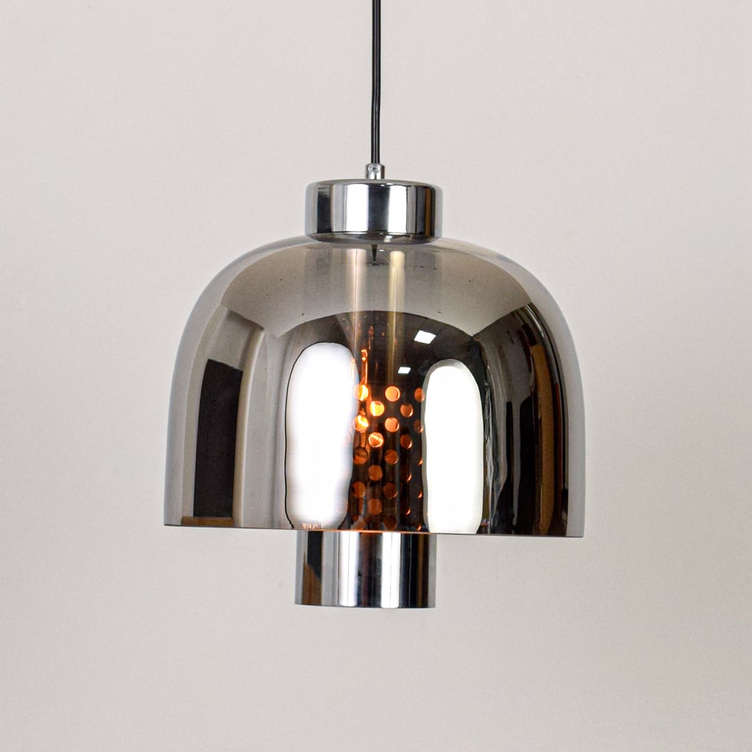 Smoke glass and chrome metal pendant light designed for modern dining room and home decor spaces.