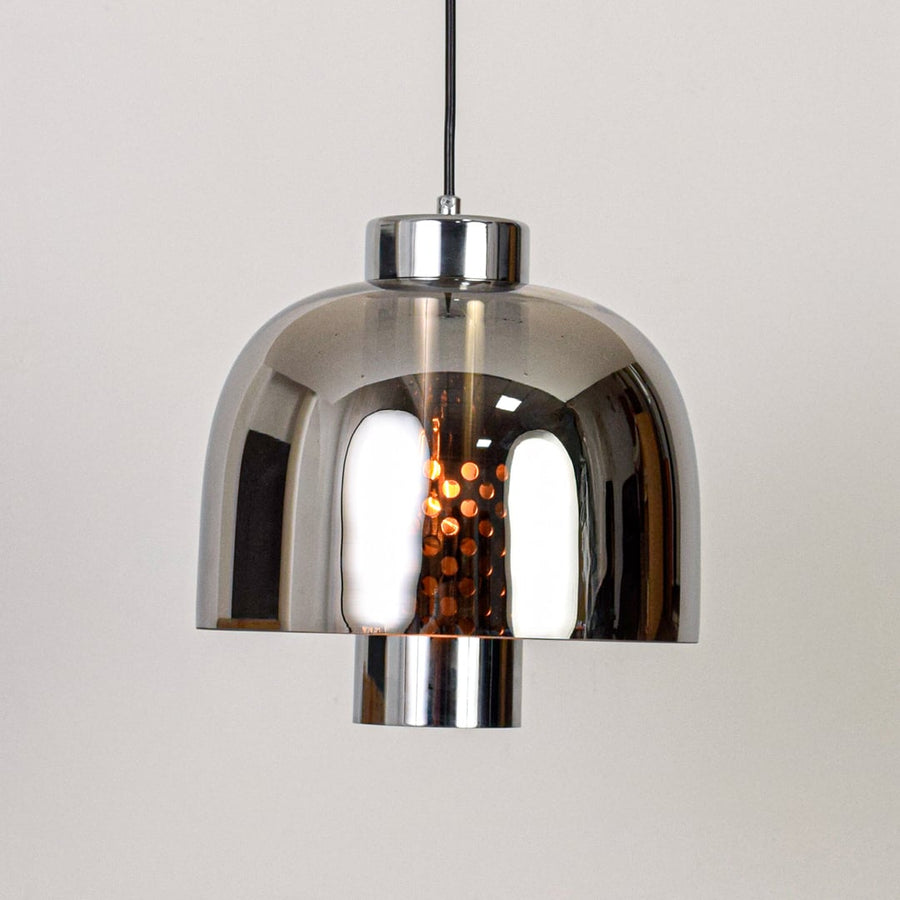 Smoke glass and chrome metal pendant light designed for modern dining room and home decor spaces.