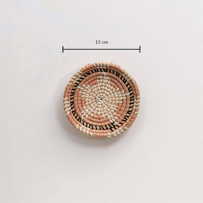 Handwoven seagrass round wall basket decor in natural beige with coral woven center and size guide on white background.