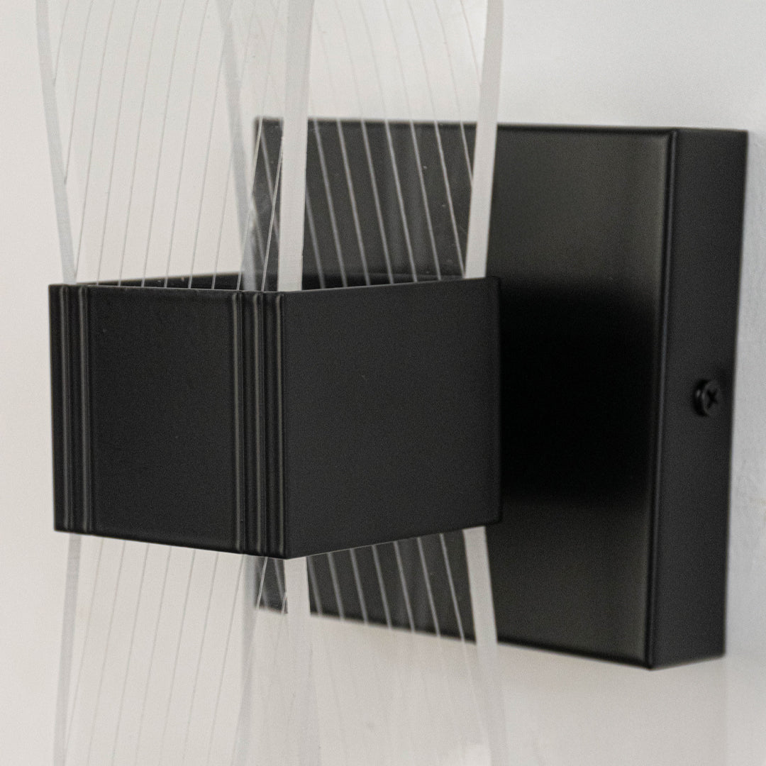 Contemporary metal wall light in black finish with geometric design for living room or hallway decor lighting white background.