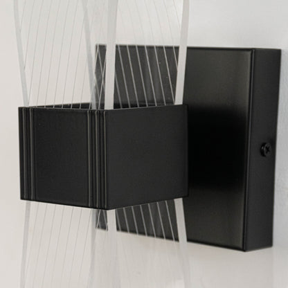 Contemporary metal wall light in black finish with geometric design for living room or hallway decor lighting white background.