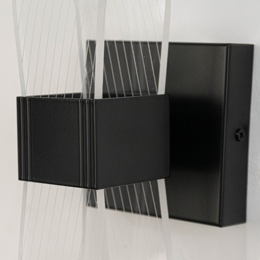 Contemporary metal wall light in black finish with geometric design for living room or hallway decor lighting white background.