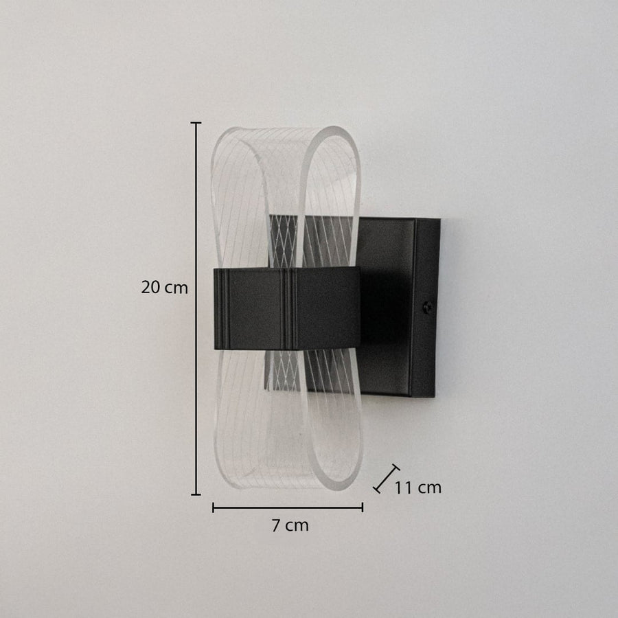 Black wall light with curved acrylic shade shown with height 20 cm width 7 cm and depth 11 cm.