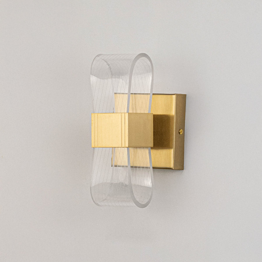 Contemporary wall light in gold metal finish with layered glass design for bedroom or living decor lighting placement white background.