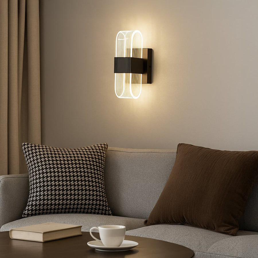 Black metal wall light with ribbed clear glass shade adding modern ambient lighting to a stylish home interior.
